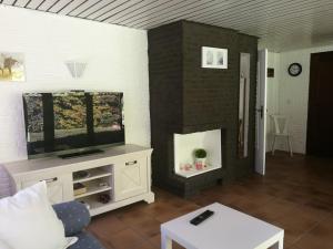Tara´s B&B Ferienwohnung في Langlingen: غرفة معيشة مع تلفزيون بشاشة مسطحة وأريكة