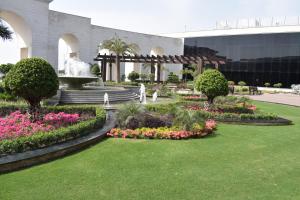 un jardín con flores y una fuente frente a un edificio en Defence Raya Golf & Country Club, en Lahore
