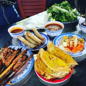 a table with plates of food and bowls of food at Quynh Chau Homestay Hội An in Hoi An