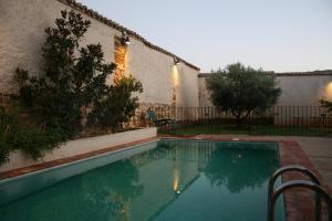 a swimming pool in a yard next to a building at La Posada Del Corralón in Alcoba