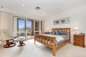 um quarto com uma cama, uma cadeira e uma janela em Adelaide Style Accommodation-Close to City-North Adelaide-3 Bdrm-free Parking em Adelaide