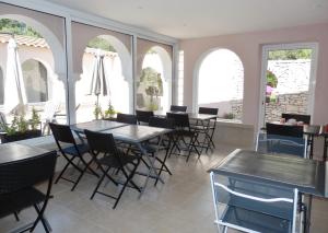 een eetkamer met tafels en stoelen en ramen bij Domaine De Foresta in Bonifacio