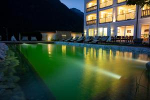 a swimming pool in front of a building at night at Hotel Heigenhauser Superior in Waidring