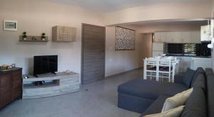 a living room with a couch and a tv and a kitchen at Politakis Apartment in Keramoti