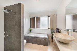 a bathroom with a tub and a sink and a bath tub at Adelaide Style Accommodation-Close to City-North Adelaide-3 Bdrm- FREE Parking in Adelaide +66 photos