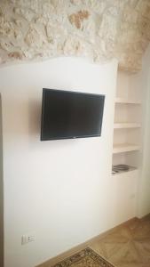 einen Flachbild-TV an einer weißen Wand in der Unterkunft Solis Domus - Meridies in Ostuni