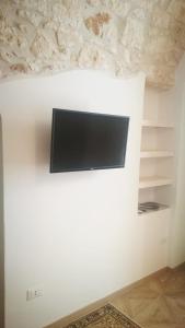 a flat screen tv on a white wall at Solis Domus - Meridies in Ostuni
