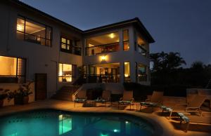 a large house with a swimming pool in front of it at Lavender Moon Guest House in Durban