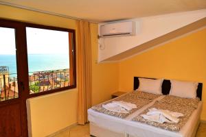 a bedroom with a bed with a view of the ocean at Joro Guest House in Sveti Vlas