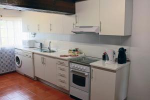 a kitchen with a sink and a stove top oven at Quinta da Ti Júlia in Tomar