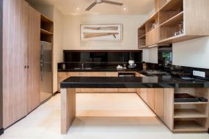 
a kitchen with a sink, stove, cabinets and a refrigerator at Cicada Luxury Townhouses in Seminyak
