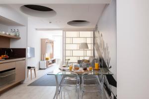 a kitchen and living room with a table and chairs at Eric Vökel Boutique Apartments - Hamburg Suites in Hamburg