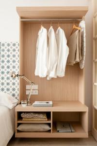 شقق إيريك فوكيل البوتيكية - أجنحة هامبورغ في هامبورغ: غرفة نوم بها مكتب وبعض الملابس