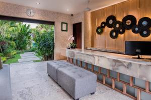 a living room with a couch and a counter at Cicada Luxury Townhouses in Seminyak