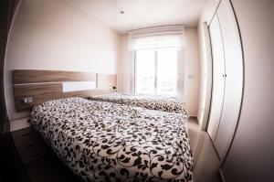 1 dormitorio con 1 cama con edredón blanco y negro en Villa Filipinas 16, en Villacosta