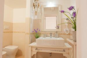 a bathroom with a sink and a toilet and a mirror at B&B Gallipoli Vecchia in Gallipoli