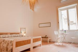 a bedroom with a bed and a table and a window at B&B Gallipoli Vecchia in Gallipoli