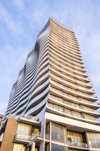 wysoki budynek z niebieskim niebem w tle w obiekcie Apartment ZARINA in apart-otel RESIDENC w mieście Batumi
