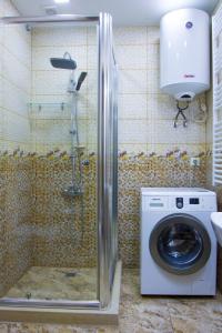 y baño con ducha y lavadora. en Apartment ZARINA in apart-otel RESIDENC en Batumi