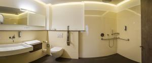 a bathroom with a toilet, sink, and bathtub at AKZENT Hotel Villa Saxer in Goslar