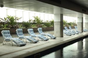 a row of blue chairs sitting next to a body of water at Defence Raya Golf & Country Club in Lahore