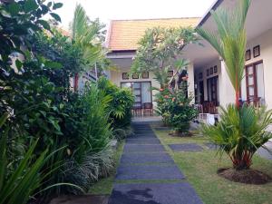 a walkway in front of a house with plants at Purnama Guesthouse in Canggu