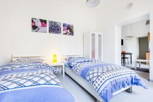 two beds in a white room with blue and white sheets at Apartments Mönchengladbach in Mönchengladbach