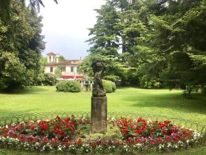 een standbeeld midden in een tuin met bloemen bij Hotel Villa Luppis in Pasiano di Pordenone