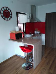 a kitchen with a counter with a red stool and a clock at Apartment Bozac in Rovinj