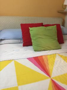 カターニアにあるAppartamento Rapisardi Centroのベッド(カラフルな枕付)