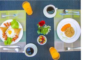 a table with plates of food and cups of coffee at Grace Treasure Hotel in Yangon