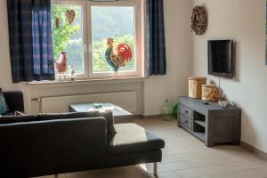 a living room with two chickens on a window at Ferienhaus am Kloster Stuben in Bremm