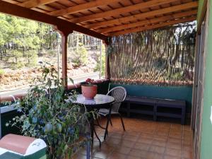 a patio with a table and chairs and a window at Casa Fagundo in Puntagorda