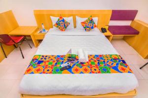 um quarto com uma cama grande e uma colcha colorida em FabExpress Picnic Plaza Mylapore em Chennai