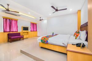1 dormitorio con 1 cama y TV. en FabExpress Picnic Plaza Mylapore en Chennai