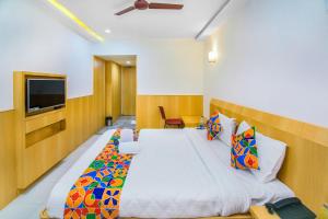 1 dormitorio con 1 cama grande y TV en FabExpress Picnic Plaza Mylapore en Chennai