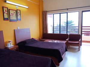 een hotelkamer met 2 bedden en een raam bij Hotel Shikhar & Restaurant in Almora