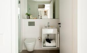a bathroom with a white toilet and a sink at Eric Vökel Boutique Apartments - Hamburg Suites in Hamburg