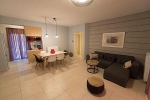 een woonkamer en een keuken met een bank en een tafel bij Kanathos Pigi in Nafplio