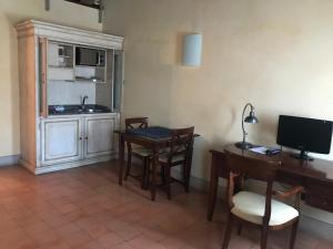a kitchen with a table and chairs and a desk at Hotel La Cantina in Medolla