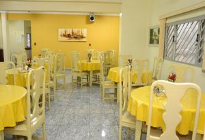 a dining room with yellow tables and chairs at Hotel Goiânia in Tucuruí