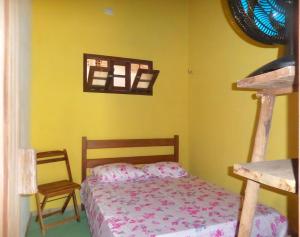 a bedroom with a bed and a chair at Casinhas Vila Bonita Amarela in Baía Formosa