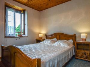 ein Schlafzimmer mit einem Bett mit zwei Tischen und zwei Fenstern in der Unterkunft Holiday home 1km from the Gouffre de Padirac in Padirac