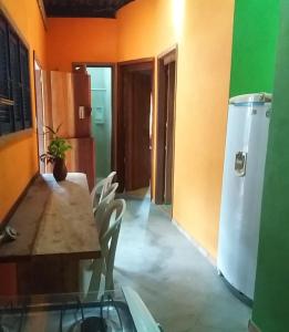 a dining room with a table and a refrigerator at Casinhas Vila Bonita Amarela in Baía Formosa