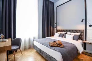 sypialnia z dużym łóżkiem z kapeluszem w obiekcie Bentis Luxury Apartments w Krakowie