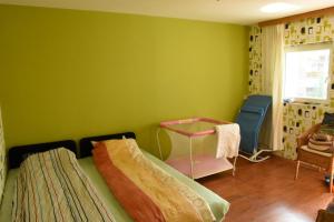 バラトンフェニヴェシュにあるLovely apartment at Balatonfenyvesの緑の壁、ベッド付きのベッドルーム1室