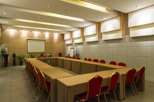 une salle de conférence avec des tables, des chaises et un écran dans l'établissement Jinjiang Inn Select Tieling Kaiyuan Xinhua Road, à Kaiyuan