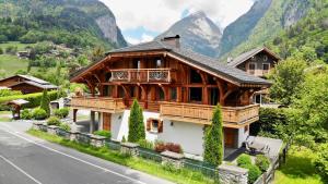 a large wooden house on the side of a road at Chalet Clos Moccand in Samoëns