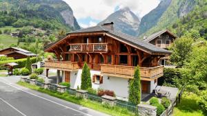 ein großes Holzhaus am Straßenrand in der Unterkunft Chalet Clos Moccand in Samoëns