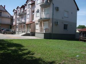 a large apartment building with a car parked next to it at Csorvy Apartman in Hajdúszoboszló